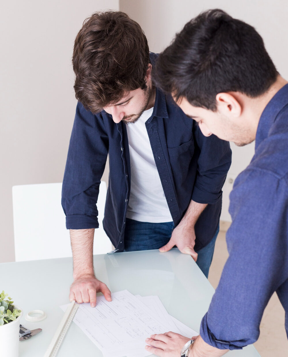 Collaboration technique chez dr-menuiserie à Tarn autour de plans détaillés sur table en verre